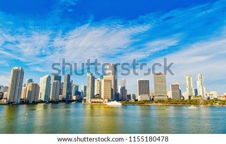 miami life and real estate property.Aerial view of Miami skyscrapers with blue cloudy sky,white boat sailing next to Miami downtown
