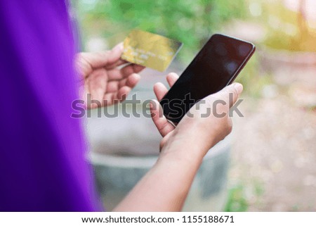 blurred of people use credit card and smart phone for shopping online.