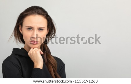 girl frowns and looks strictly into the frame Royalty-Free Stock Photo #1155191263