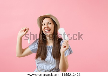 Portrait of young woman in blue dress holding sanitary napkin, tampon for variant safety menstruation days isolated on pink background. Medical healthcare, gynecological, choice concept. Copy space Royalty-Free Stock Photo #1155213421