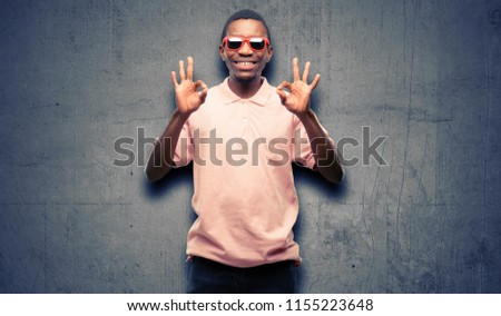 African black man wearing sunglasses doing ok sign gesture with both hands expressing meditation and relaxation