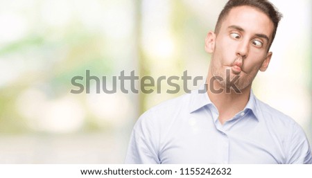 Handsome young businessman making fish face with lips, crazy and comical gesture. Funny expression.