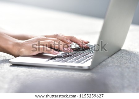 Young businesswoman sitting at street working with laptop, close-up photo. Business, education, lifestyle concept.