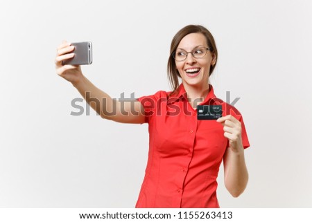 Excited business woman in red shirt doing taking selfie shot on mobile phone with credit bank card, cashless money isolated on white background. Education teaching in high school university concept