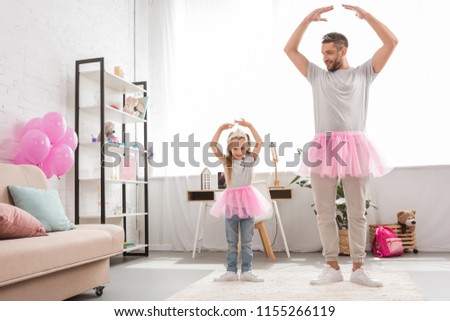 father and daughter in pink tutu skirts dancing like ballerinas Royalty-Free Stock Photo #1155266119