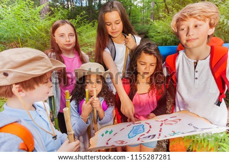 Kids with map on treasure hunt navigation activity Royalty-Free Stock Photo #1155287281