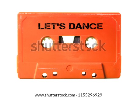 A vintage cassette tape from the 1980s era (obsolete music technology) with the text Let's Dance printed over it (my addition, not in the original image). Color: coral red. White background.
