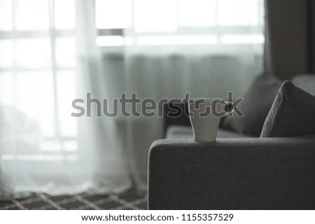A cup of coffee. Gray sofa. Big window. Scandinavian style. Copy space