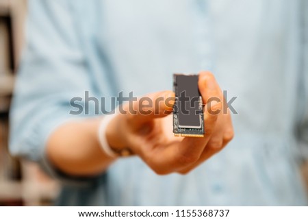 Horizontal photo of woman holding demonstrating new NVME PCIE SSD hard drive disk with high read and write speed