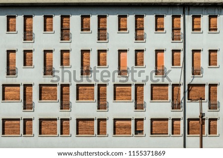 Concrete facade with series of facade of windows and small balconies
