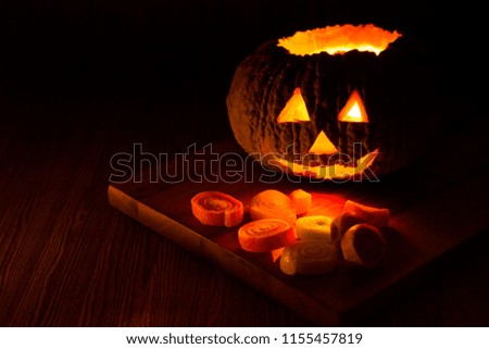 Halloween pumpkin head jack o lantern with dark background on wooden floor