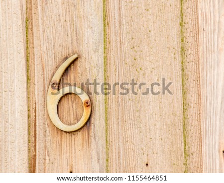 Rusty Old Number Six on a Wooden Background