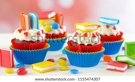 Bright colorful Back to School theme cupcakes with candy sugar art book topper decorations, children's party celebrations.
