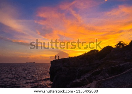 Silhouette of people taking picture with sun set sky background and boat