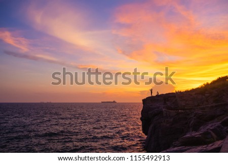 Silhouette of people taking picture with sun set sky background and boat