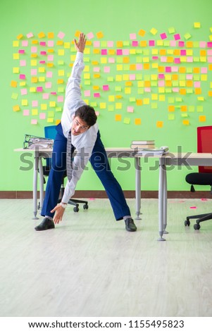 Man in the office with many conflicting priorities doing exercis