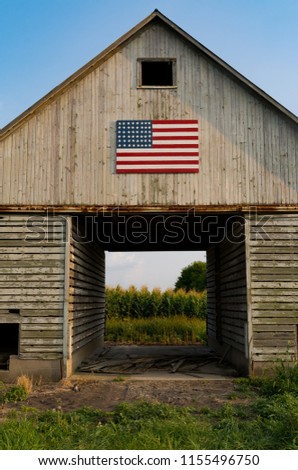 Old rustic barn with painted American flag as the sun starts to set.  LaSalle County, Illinois, USA