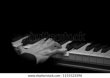 Musician is playing piano with Black background.