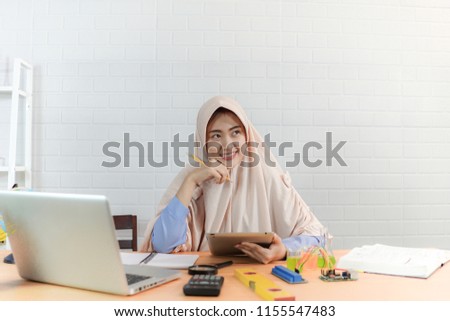 Beautiful Muslim business woman, working in office, she uses a laptop computer to working and study. education concept.