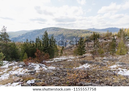 autumn landscape in the mountains with the first snow, stone surface