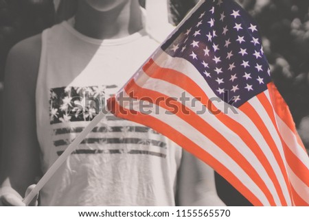 Teenager holding US Flag in hands. 4th of July celebration during COVID-19 pandemic