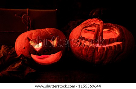halloween concept. two spooky halloween pumpkin with candles on wooden table with autumn leaves