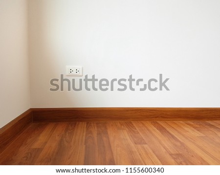 Empty white room with white walls and wooden parquet floor with wall point plug for housing