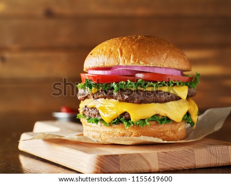 double cheeseburger with lettuce, tomato, onion, and melted american cheese Royalty-Free Stock Photo #1155619600