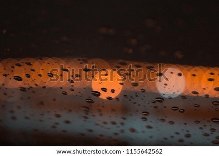 Bokeh light in the back of rain drops on windshield