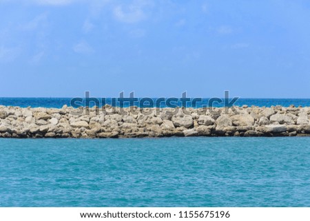scenic view. natural stone breakwater in the sea. smooth symmetrical horizon