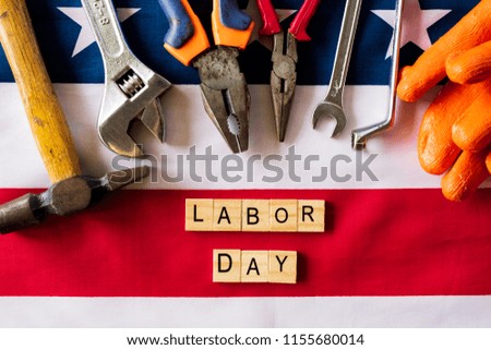 USA Labor day concept, First Monday in September. Different kinds on wrenches, handy tools, America flag and wooden blocks on wooden table.