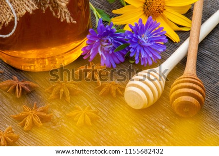 Honey in jar with honey spoon on vintage wooden background