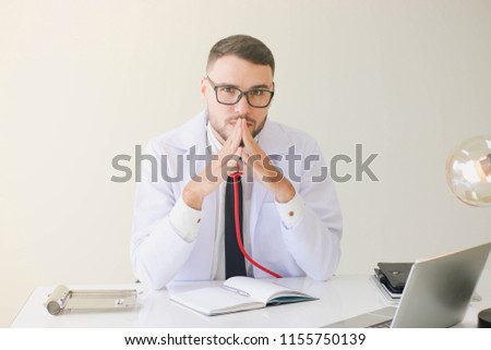 Doctor sitting on someone's desk, the idea to show professionalism.