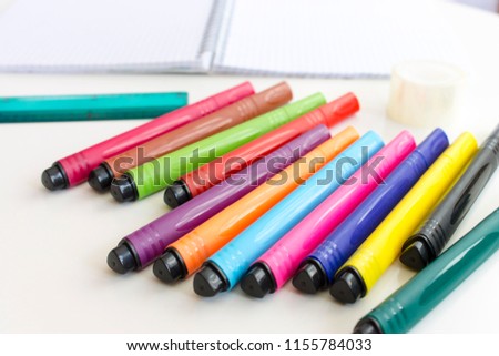 Multicolored marker pens, office and school drawing art design. Blurred notebook and ruler on background