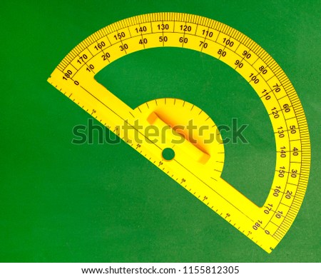 The yellow angle protractor on green chalkboard in classroom