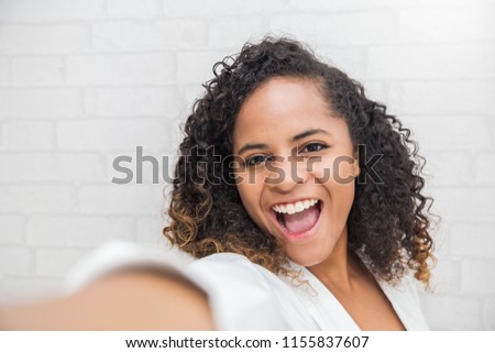 Pretty african american girl take a selfie portrait with her smartphone. Closeup beauty woman say hi selfie indoor. People lifestyle technology connection social online network blog concept