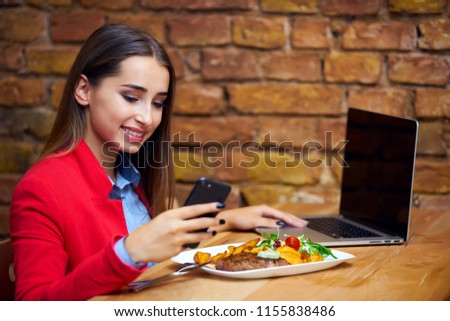 Business girl talking on phone while eating at restaurant