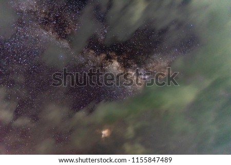Night sky, star and center of Milky way behind the moving clouds.
