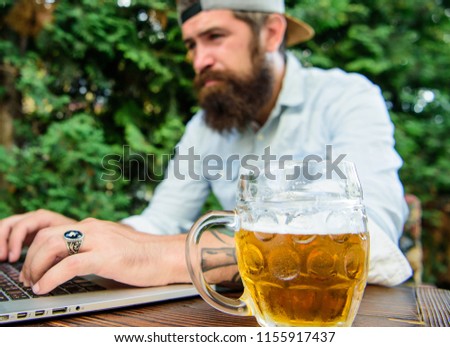 Fan bet online championship while sit terrace outdoors with beer. Football fan bearded hipster make bet sport game laptop. Betting and real money gaming. Brutal man leisure with beer and sport game.