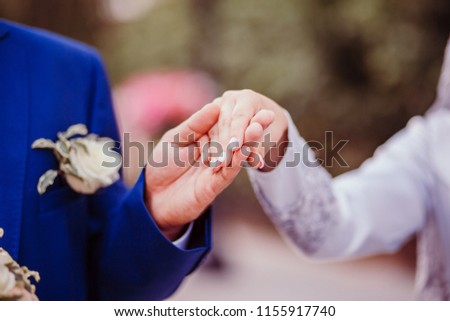 Wedding couple holding hands on sunset. Wedding rings. Man giving an engagement ring to his girlfriend