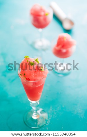 Warermelon granita
on a small glass over a blue background with focus selective technique