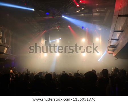 Blur image of concert, Celebration party, light and sound entertainment, having fun on holidays, new year, christmas party. abstract photo use for background. Crowd people dance in night-club.