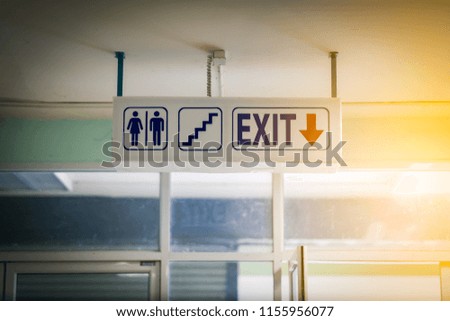 Blurred sign toilet and exit direction 