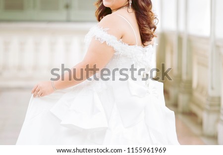 Plus size bride in white wedding dress in the garden /happy wedding concept
