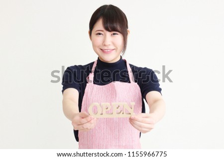 Young Asian woman entrepreneur showing open sign