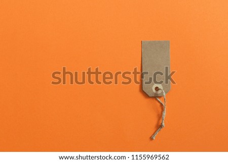 Brown etiquette of kraft cardboard on an orange background. Mockup. Sale theme.