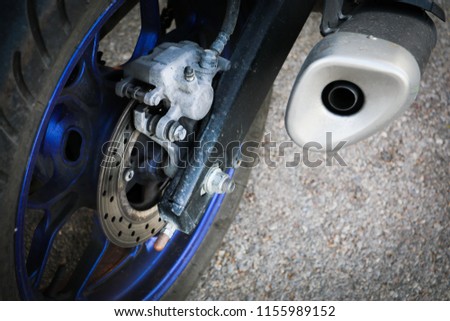 The brake disk and exhaust of the motorcycle. Detail photo concept of the motorbike part.