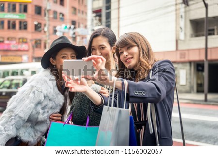 Three women doing shopping outdoors - Best friends meeting while shopping in Tokyo