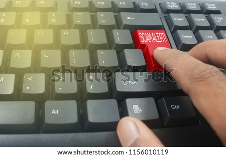 finger pressing red scam alert button