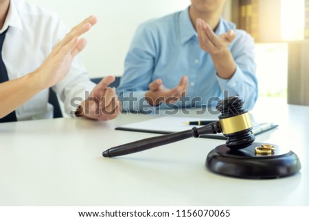 woman and man quarrel in front of gavel on the table with paper for sign